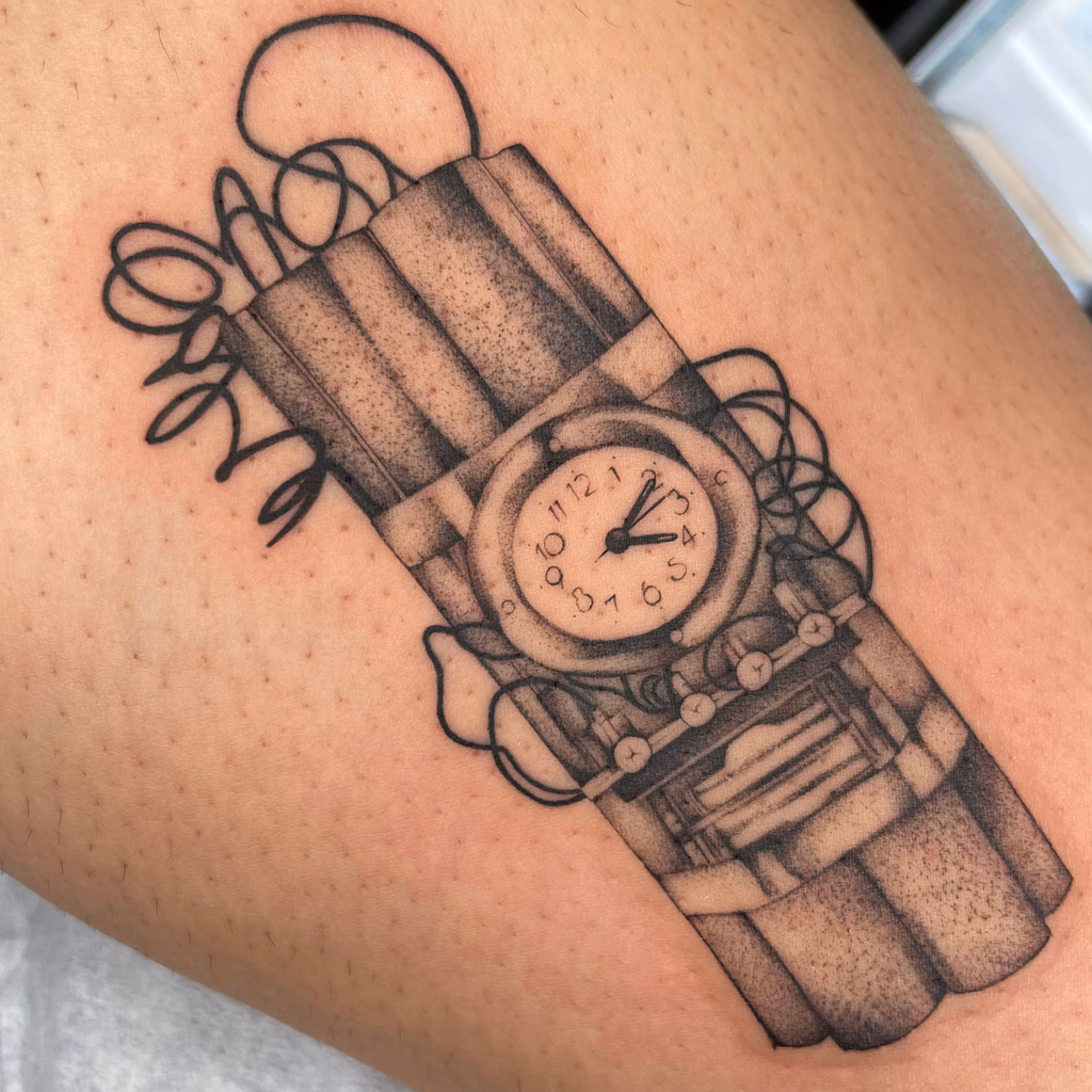 Black and grey illustrative tattoo of a watch bundled with candles and foliage.